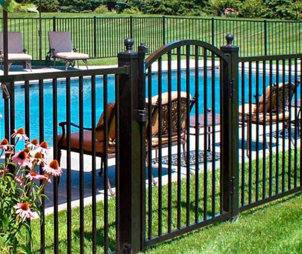 Black aluminum pool fence with arched walk gate and ball-cap posts