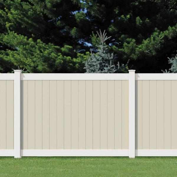 Beige vinyl privacy fence panels installed along the perimeter of a residential backyard