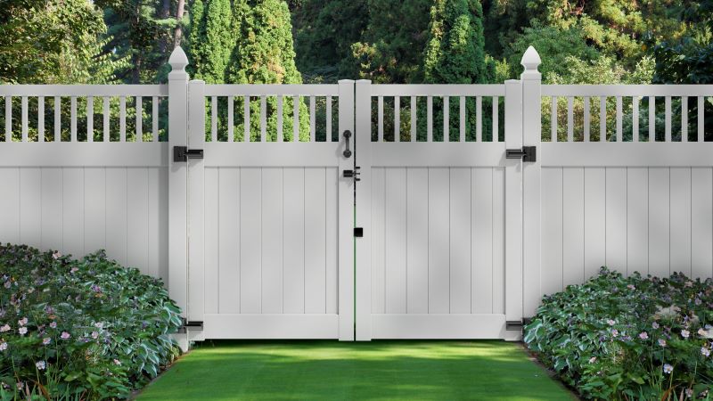 White vinyl privacy fence with spindle top and matching double drive gate