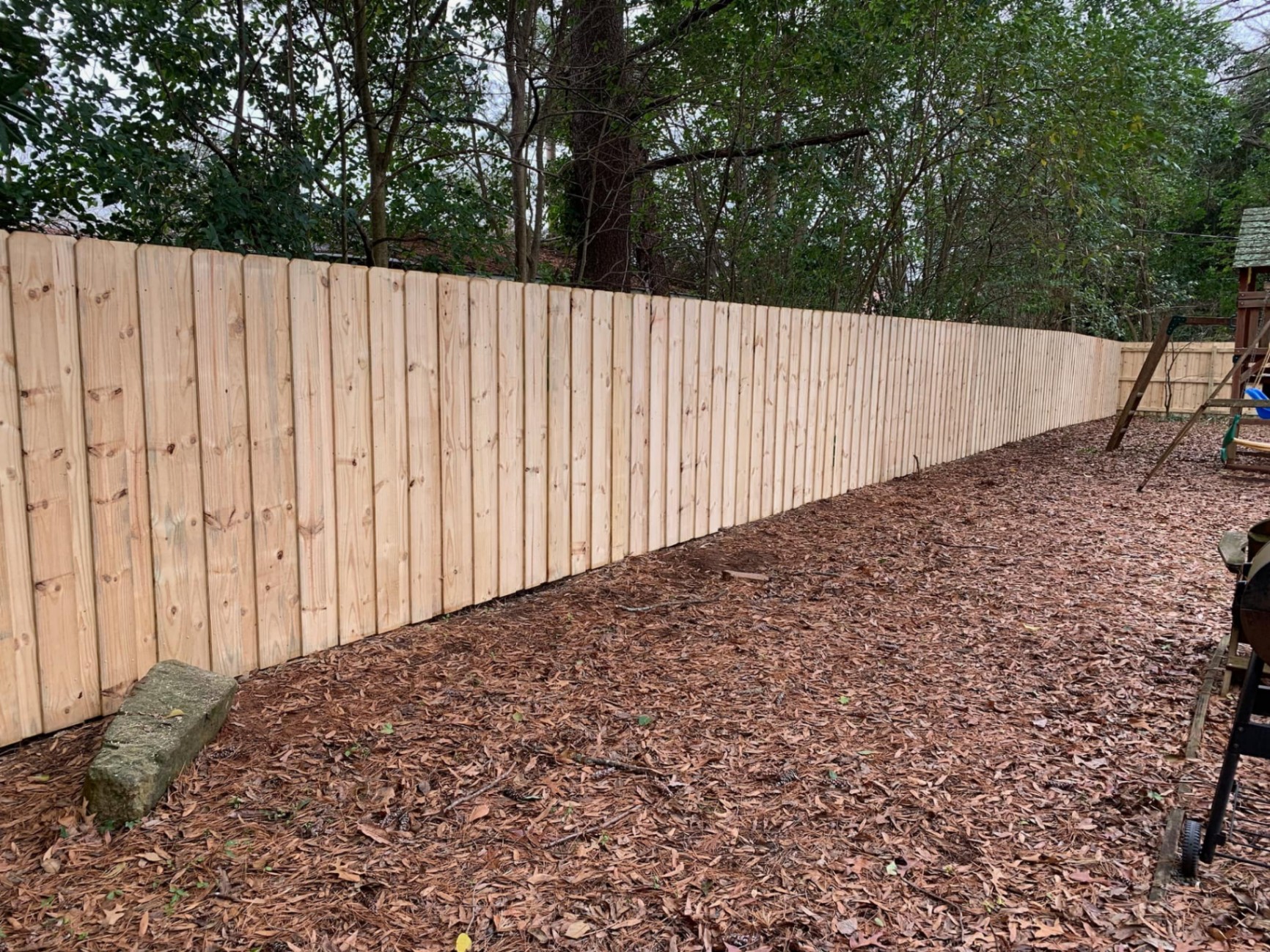 Pressure-treated pine board-on-board privacy fence along a north Atlanta backyard