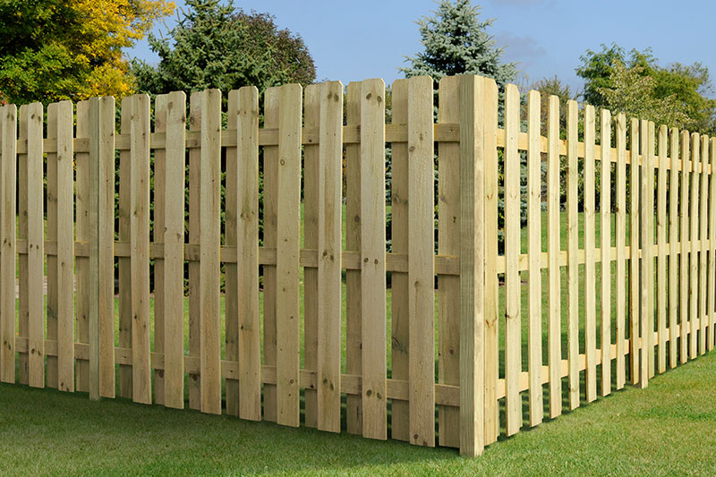 Six-foot pressure-treated pine shadowbox fence along a residential backyard