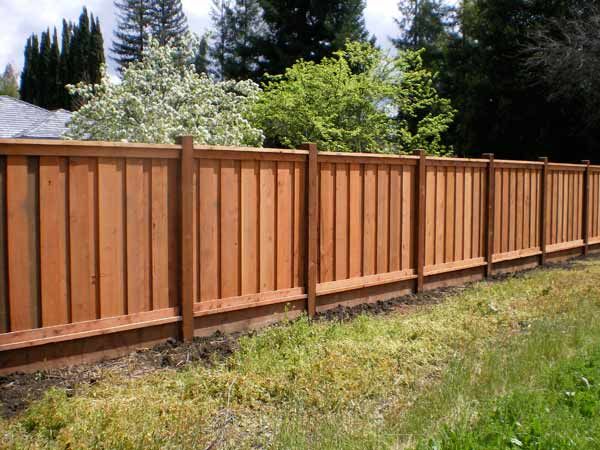 Craftsman-style cedar privacy fence with cap and trim and visible post tops